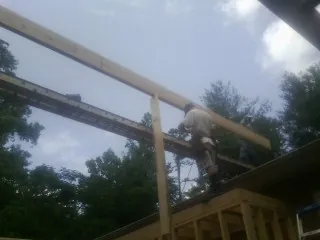 Carpenter setting a ridge beam over a new addition frame — Ice Dam Removal by Roofing Brothers in Boalsburg