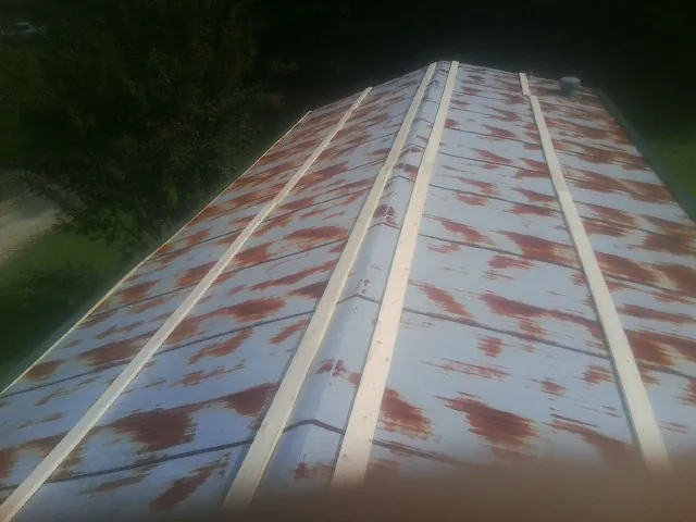 Rusted metal roof panels with new wood purlins before replacement — Storm Damage Roof Repair in Boalsburg by Roofing Brothers