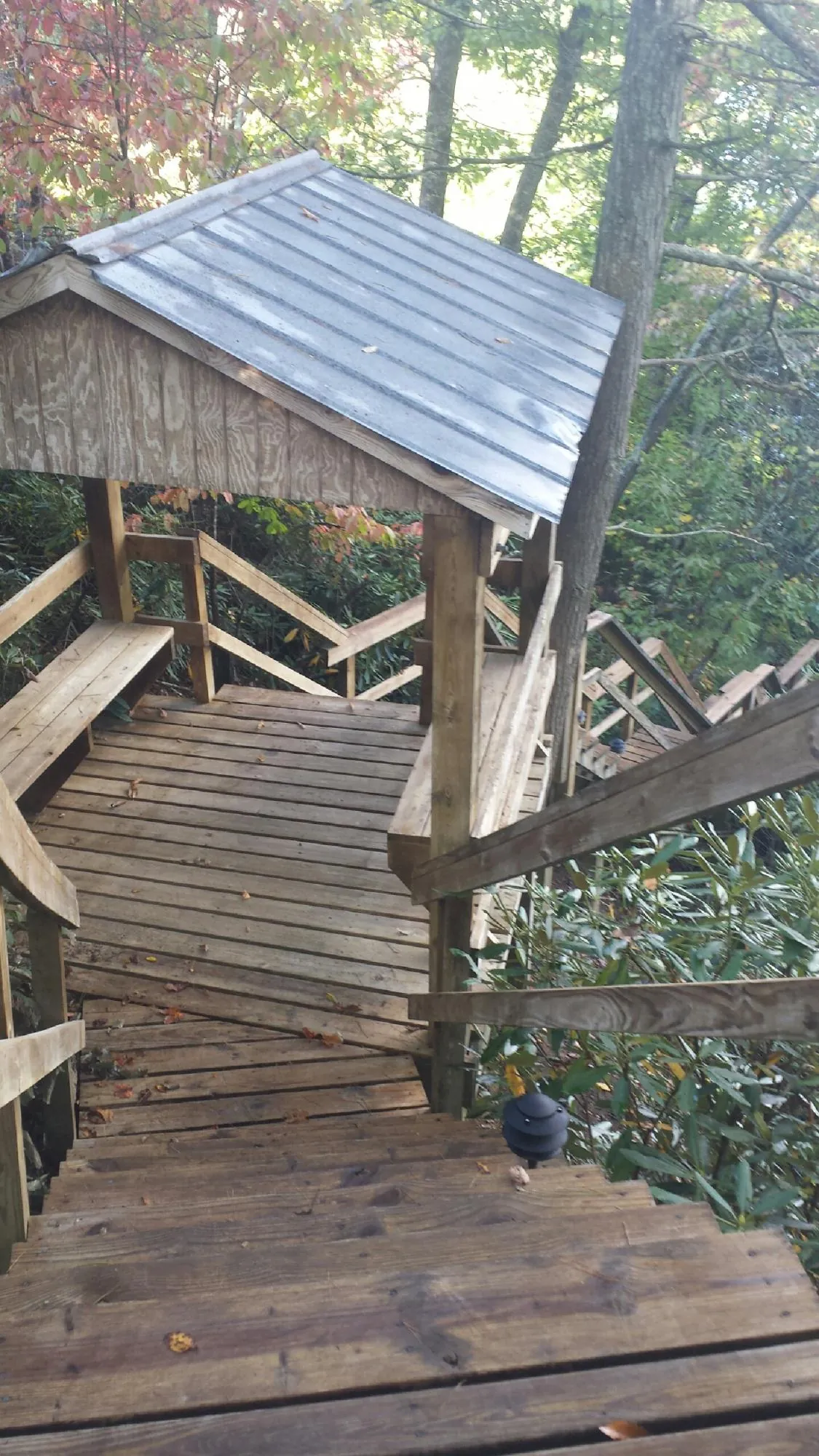 Metal roofed shelter over wooden steps on a wooded walkway — Skylight Repair & Installation work by our crew in Boalsburg
