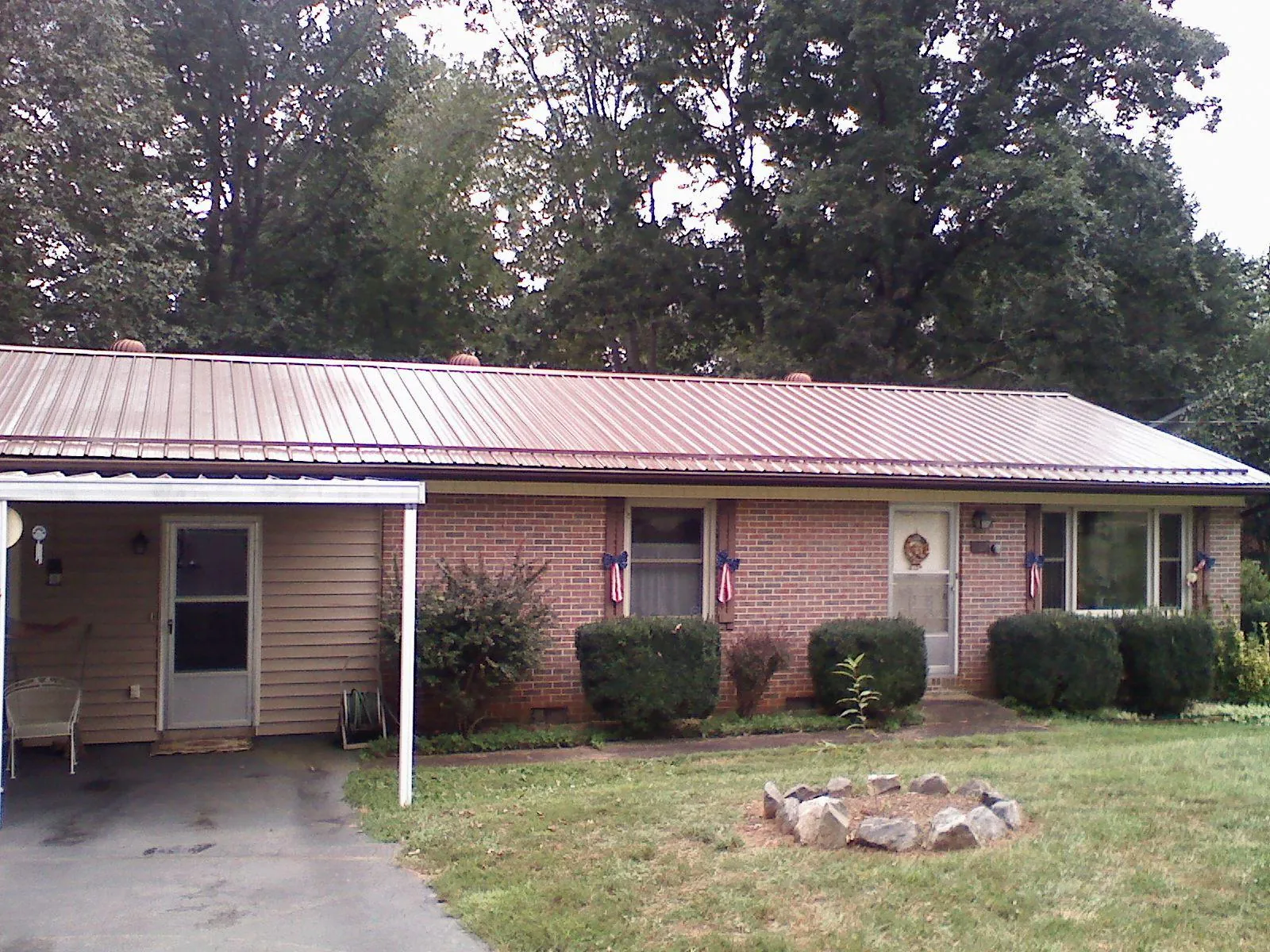 Bronze metal roof and carport on a brick ranch home — Roof Repair work by our crew in Boalsburg